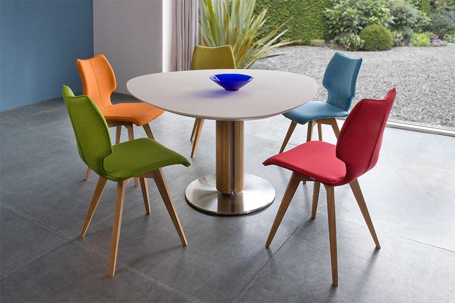 A set of four customised dining chairs each upholstered in a different colour