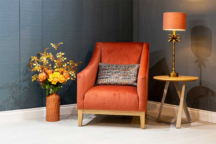 A customised Archer armchair upholstered in burnt orange stain resistant velvet fabric