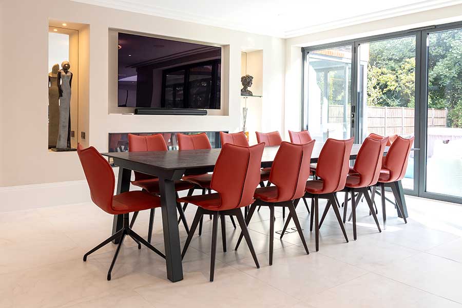 A large 12 seat Dekton dining table with red leather dining chairs