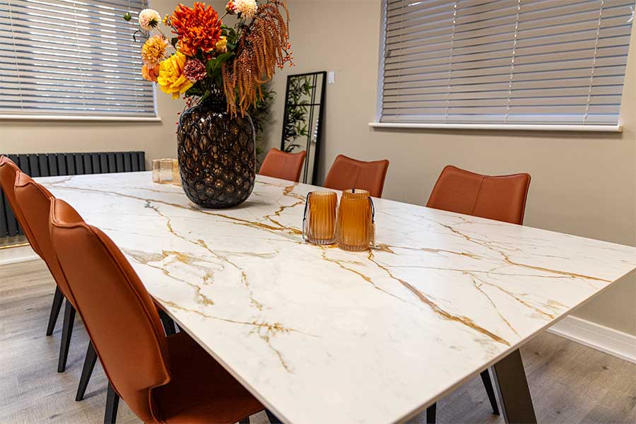 Large marble effect Dekton dining table with gold surface veining