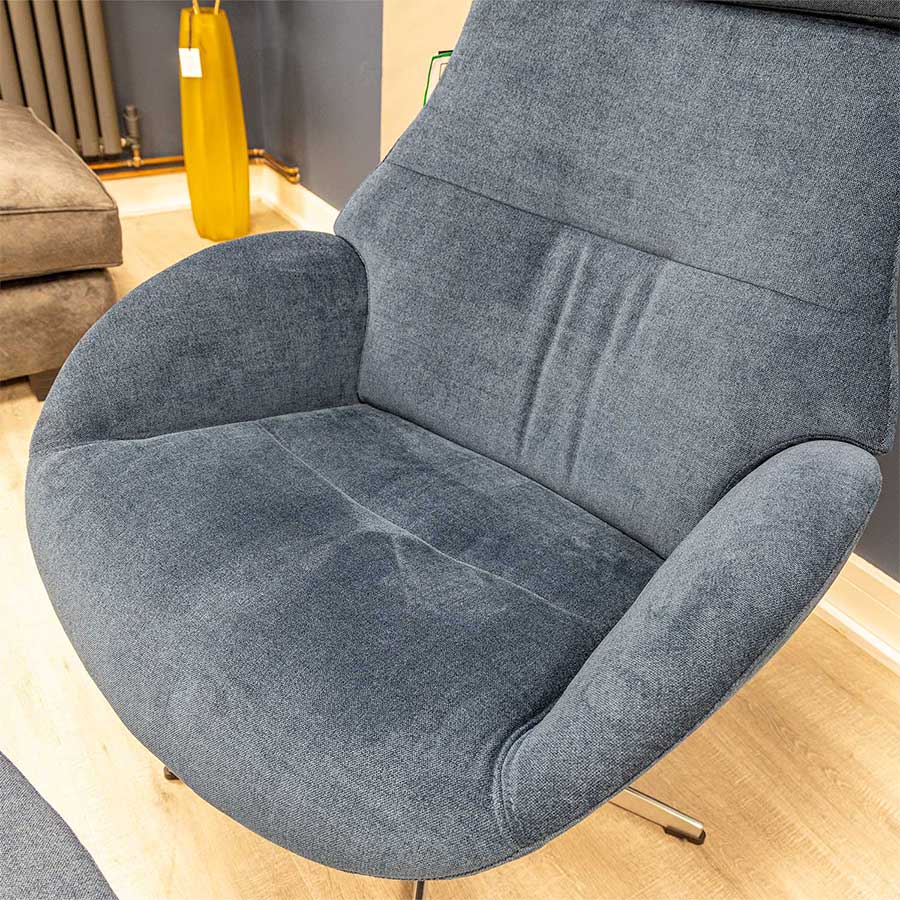 The inviting seat of a Conform Globe swivel armchair in dark blue fabric